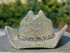 I am now offering custom bedazzled cowboy hats that sparkle beyond belief due to the high quality glass crystal rhinestones I use. I can make yours using a hat of your choice if you prefer to supply your own, or from a selection of 5 colors I have sourced that are good quality faux suede: White, ivory, Tan, Pink or Black.  They come in two sizes S/M or L/XL. These hats are made to last! They require almost 30 hours of meticulous labour. The brims are covered in rhinestones using permanent adhesive both upper and under sides for extra spectacular sparkle! I can source any color rhinestones, so feel free to message me about color choices or options. If you prefer a lower cost option that weighs a little less, I can use resin rhinestones instead, but I suggest the glass crystals for their sup Bejeweled Cowboy Hat, Silver Hat With Rhinestones For Rodeo, Silver Rhinestone Hat For Rodeo, Western Bling Hat For Rodeo, Western Hats With Bling For Rodeo, Western Silver Hat With Rhinestones, Western Style Bling Hats For Rodeo, Western Style Hat With Bling And Curved Brim, Festival Hats With Rhinestones And High Crown