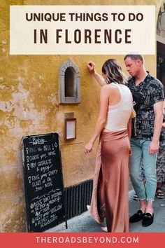 a man and woman standing in front of a sign that says unique things to do in florence