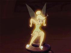 the animated tinkerbell figure is sitting on top of a round object with glowing lights