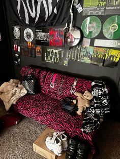 a room with various items on the floor and walls covered in posters, cds, and t - shirts