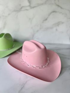 "Hand panted pink cowboy hat with acrylic chain detail. Perfect for bachelorettes! Comes with clear chain, pink clear chain, or pink opaque/matte chain. Message me about custom designs and colors! Order two or more items and receive free ground shipping!! Discount reflected in checkout. **I have a new style of cowboy hat AND new paint colors that vary slightly from hats I released in 2021** - The hat you will receive is the style and color in the first photo. Hats with the old style and color ar Bachelorette Cowgirl, Pink Cowboy Hat, Pink Cowboy, Taylor Outfits, New Paint Colors, Pink Friday, Cowgirl Hat, Cowgirl Hats, Hat Band