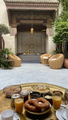 a table topped with food and drinks on top of a gold tray next to a fireplace