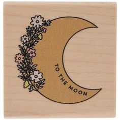 a wooden stamp with the words to the moon and flowers on it's side