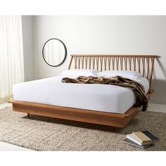 a bed with a wooden frame and white sheets