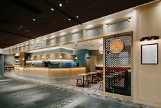 the inside of a restaurant with tables, chairs and counter tops in an open area