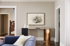 a living room with a blue couch and wooden table in front of the door way