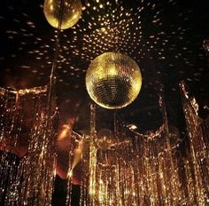 disco balls are hanging from the ceiling in this dark room with lights all over it