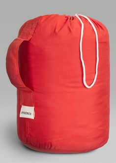 a large red bag sitting on top of a gray floor