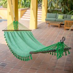 a green hammock hanging from a patio