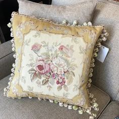 a pillow with flowers on it sitting on a couch