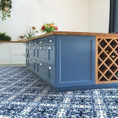 a blue kitchen island with wine rack on top