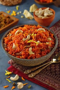 a bowl filled with food sitting on top of a blue table cloth next to other dishes