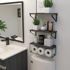 a bathroom with a toilet, sink and shelves on the wall next to the mirror