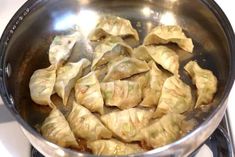 some dumplings are cooking in a pan on the stove