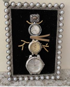 three watches in a frame with pearls around the edges