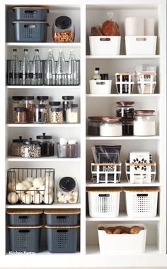 an organized pantry with white shelves and baskets