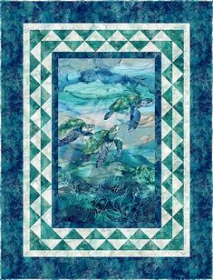 a quilt with sea turtles on it and blue water in the background, as well as green