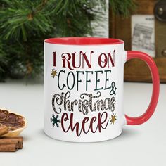 a red and white coffee mug sitting on top of a table next to cinnamons