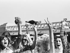 a group of people standing next to each other with their hands up in the air