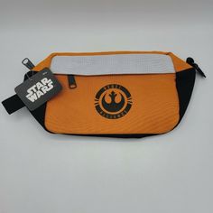 an orange star wars pencil case with a black and white stripe around the bottom that has a logo on it