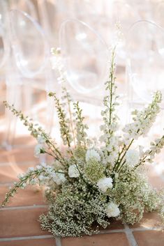 a vase filled with lots of white flowers on top of a tiled floor covered in bubbles