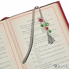 an open book with a metal tie on it's side and some beads attached to the end