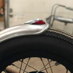 the front wheel of a bicycle with a red light on it's brake end