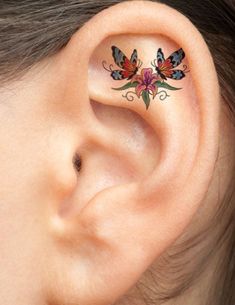 a woman with a butterfly tattoo on her ear