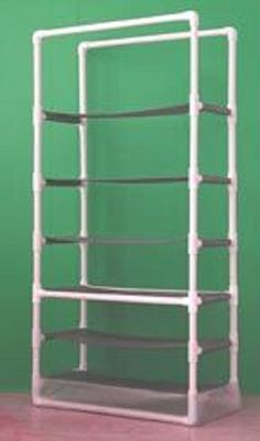 a white rack with six shelves on top of a wooden floor next to a green wall