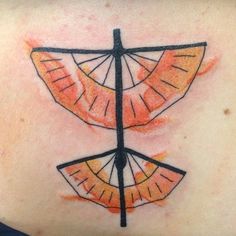 the back of a woman's shoulder with an orange and black design on it