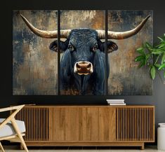 a painting of a bull with large horns on it's face is displayed in a living room