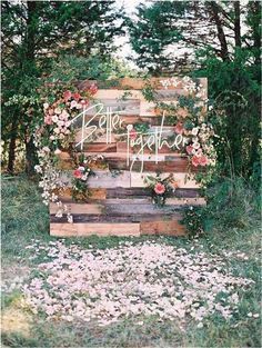 an old pallet is decorated with flowers and greenery