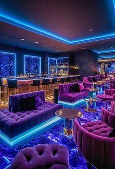 purple couches and chairs in a room with blue lights