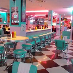 the interior of a diner with checkered flooring and neon lights on the walls