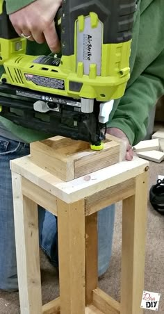 a person using a power tool on a piece of wood that is sitting on top of a table