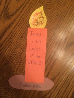 a piece of paper that says jesus is the light of the world on top of a wooden table