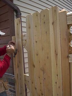 a man is working on a wooden fence