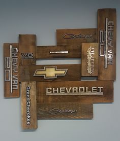 wooden signs with chevrolet logos on them are hanging from the wall in front of a gray background