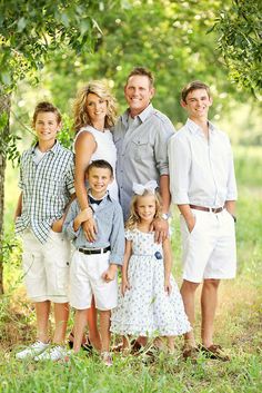 a family posing for a photo under some trees