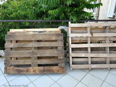 two wooden pallets sitting on top of a tiled floor next to each other in front of trees