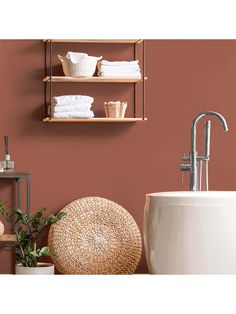 a bath room with a toilet and a tub next to a shelf filled with towels