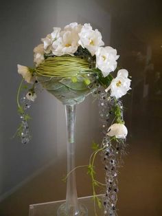 a glass vase with white flowers and greenery