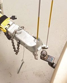 a machine that is sitting on the ground next to a pole with two chains hanging from it