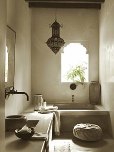 a bath room with a sink and a bath tub next to a potted plant