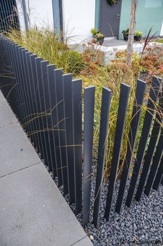 a black metal fence with grass growing between it