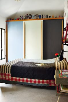 a bed sitting in a bedroom next to a book shelf filled with lots of books