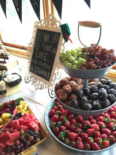 three tiered trays filled with different types of fruits and chocolate covered strawberries