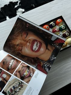 an open magazine with pictures of women's face and jewelry on it next to pool balls