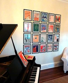 a black piano sitting in front of a wall with pictures on it