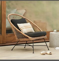 a wicker chair sitting on top of a floor next to a window